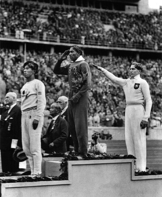 2. Tấm huy chương Berlin: Olympic 1936, Adolf Hitler làm tất cả để giúp Đức chiến thắng trong mọi nội dung thi đấu vì mục đích chính trị là tôn vinh chủng người Aryan. Có một người đã không khuất phục, đó là Jesse Owens (Mỹ) của môn nhảy xa. Và trong bức ảnh này, ta thấy một người Nhật (khi đó là đồng minh của Đức) đứng thứ 3, một người Đức (chào kiểu Quốc xã) về thứ 2, nhưng Jesse Owens hiên ngang đứng thẳng trên bục chiến thắng và hướng về lá quốc kỳ của Tổ quốc bằng tất cả sự thành kính.